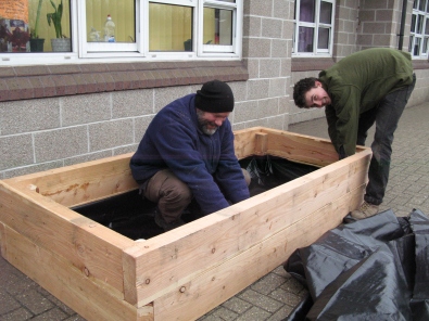Jim and Jack build the raised bed at school with a liner to retain the topsoil